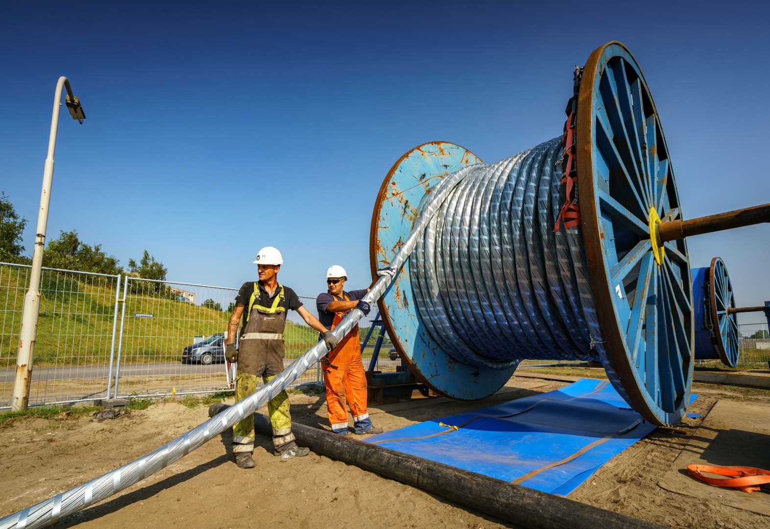 Colleagues near a spool of cabling for the Bergen op Zoom connection, Netherlands