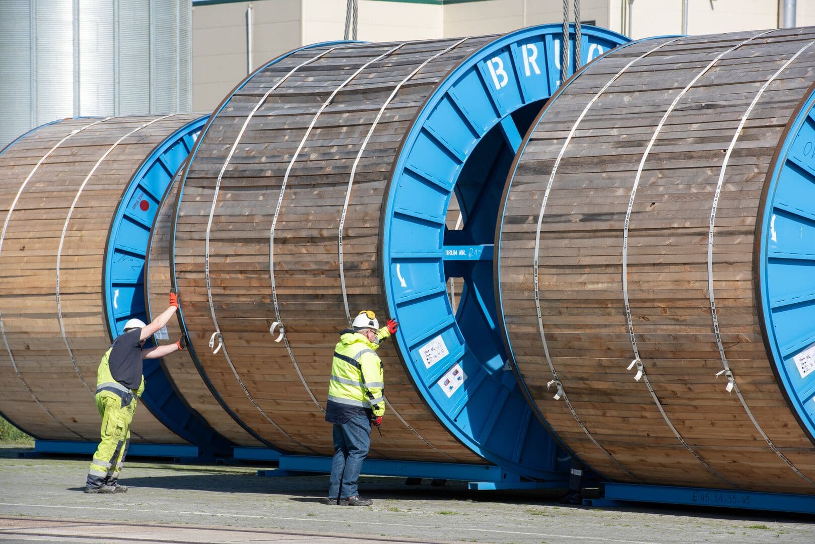 Colleagues at work, next to cable spools for the Hessen-Niedersachsen connection in Germany