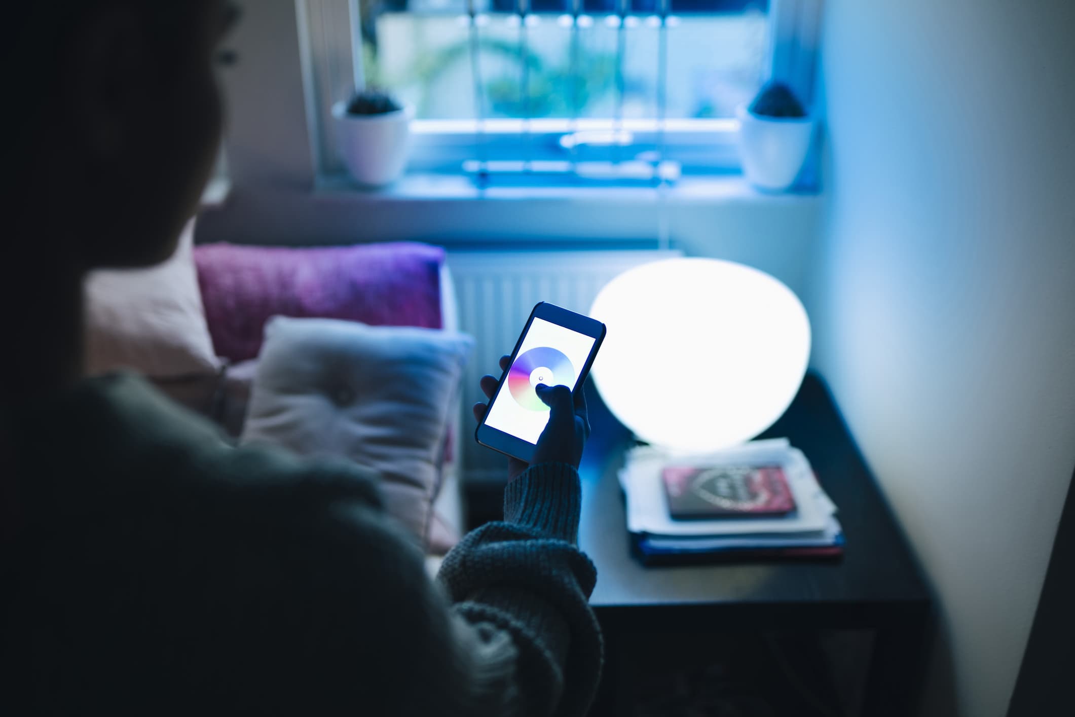 Person with smartphone and smart light
